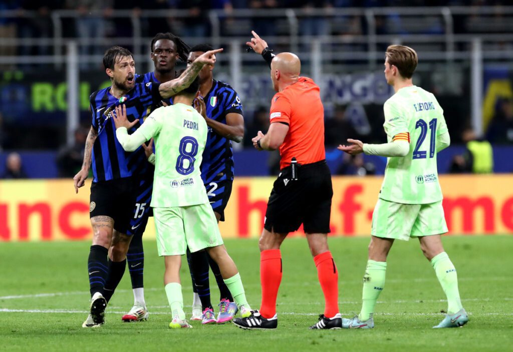 MILAN, ITALY - MAY 06: Referee Szymon Marciniak approaches Francesco Acerbi of FC Internazionale as he is held back by Pedri of FC Barcelona whilst gesturing during the UEFA Champions League 2024/25 Semi Final Second Leg match between FC Internazionale Milano and FC Barcelona at Giuseppe Meazza Stadium on May 06, 2025 in Milan, Italy. (Photo by Marco Luzzani/Getty Images)