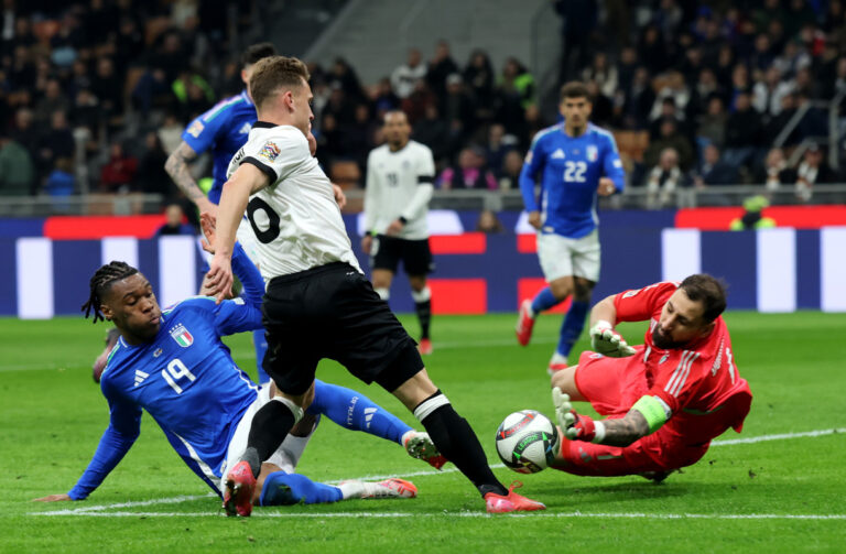 MILAN, ITALY - MARCH 20: Joshua Kimmich of Germany has a shot saved by Gianluigi Donnarumma of Italy during the UEFA Nations League quarterfinal leg one match between Italy and Germany at Stadio San Siro on March 20, 2025 in Milan, Italy. (Photo by Alex Grimm/Getty Images)