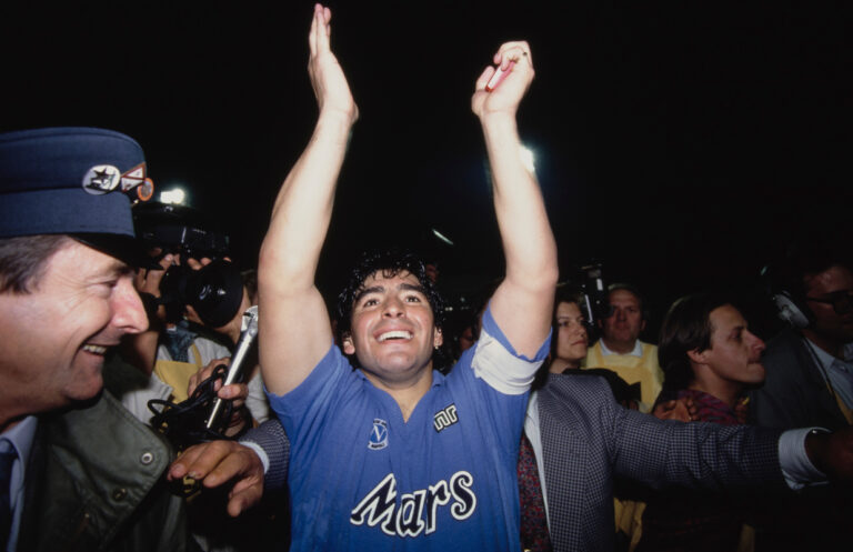 STUTTGART, GERMANY - MAY 17: Napoli captain Diego Maradona surrounded by media and police celebrates after the 1989 UEFA Cup Final second leg between VFB Stuttgart and S.S.C Napoli at Neckarstadion on May 17, 1989 in Stuttgart, West Germany. (Photo by Simon Bruty/Allsport/Hulton Archive/Getty Images)